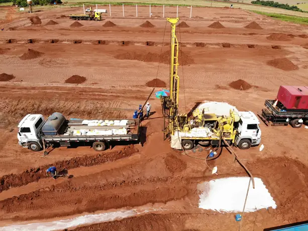 Vista aérea da perfuração de poço em obra industrial em fase de terraplanagem